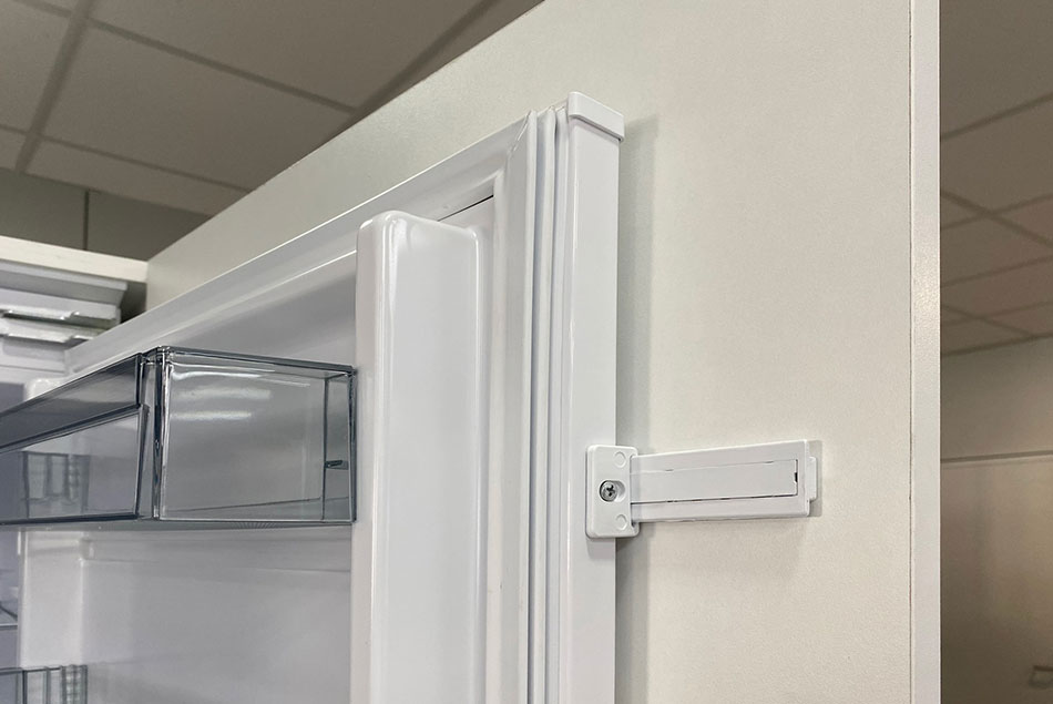 sistema de sujeción de puerta a mueble de frigorífico integrable.